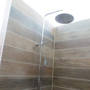 Gerenoveerde douche met Grohe douchekraan en wandtegels met houtmotief